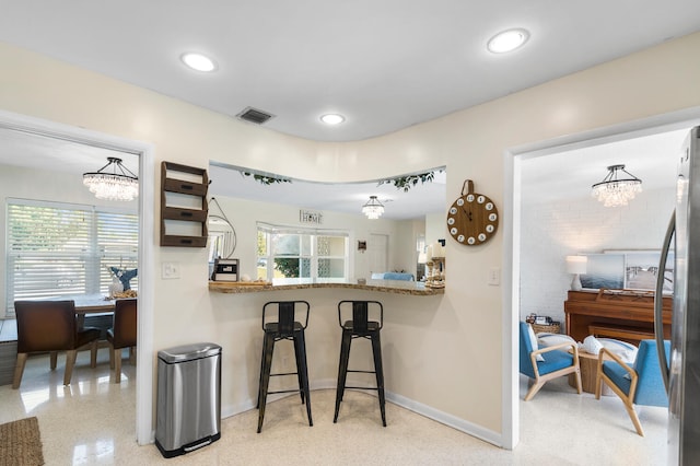 kitchen with baseboards, visible vents, light speckled floor, pendant lighting, and recessed lighting