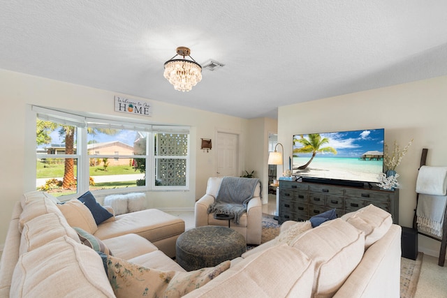 living room with a chandelier, visible vents, a textured ceiling, and baseboards