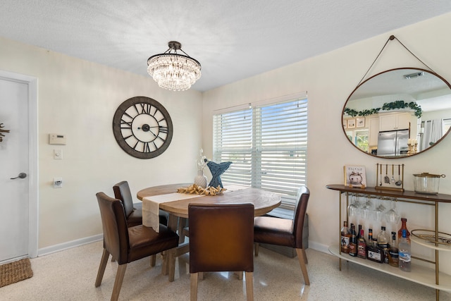 dining space with light speckled floor, a chandelier, visible vents, and baseboards