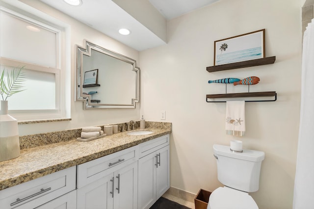 bathroom with toilet, recessed lighting, and vanity