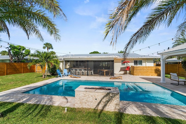 view of pool with outdoor dry bar, a yard, a patio area, and a fenced backyard