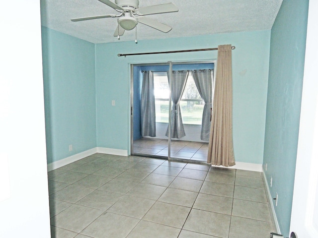 tiled empty room featuring ceiling fan and a textured ceiling