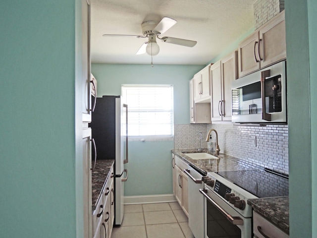 kitchen featuring stainless steel appliances, light tile flooring, ceiling fan, tasteful backsplash, and sink