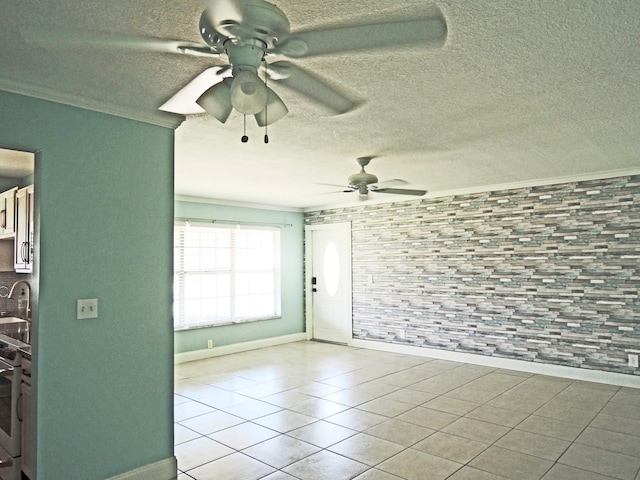 spare room with ceiling fan, a textured ceiling, and crown molding