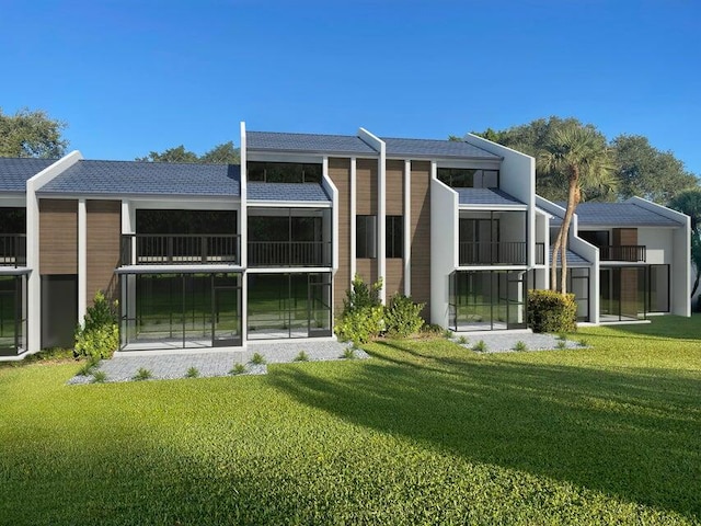 rear view of house featuring a yard and a balcony