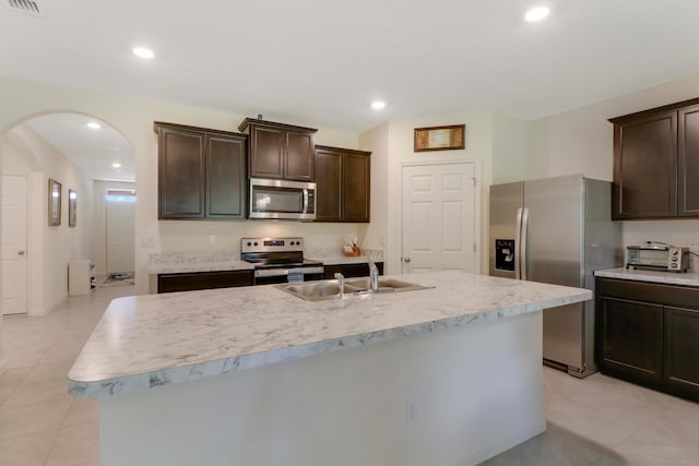 kitchen featuring appliances with stainless steel finishes, a kitchen island with sink, sink, and light tile floors