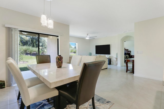 dining room with light tile floors and ceiling fan with notable chandelier