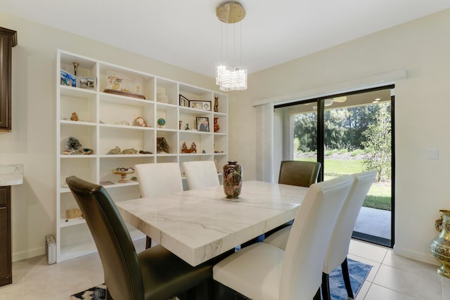 dining area featuring an inviting chandelier and light tile floors