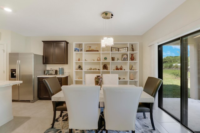 dining area featuring light tile flooring and a notable chandelier