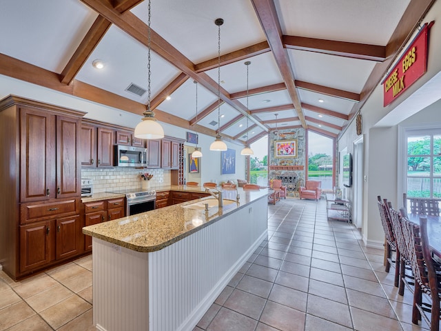 kitchen with appliances with stainless steel finishes, backsplash, hanging light fixtures, lofted ceiling with beams, and light tile floors