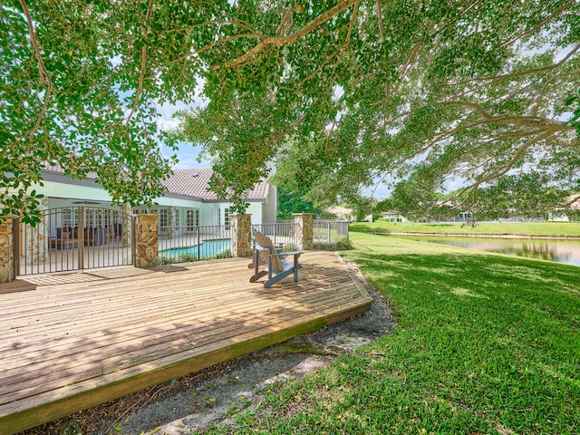 wooden deck featuring a lawn and a water view