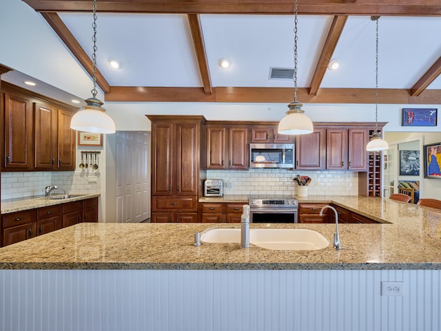 kitchen with lofted ceiling with beams, hanging light fixtures, appliances with stainless steel finishes, and backsplash