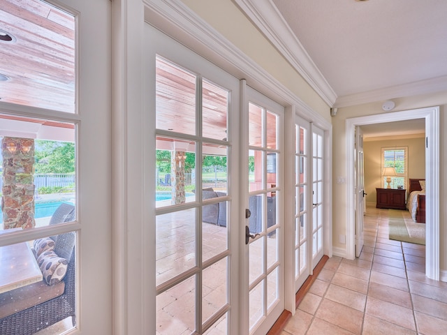 doorway with french doors, crown molding, and light tile flooring