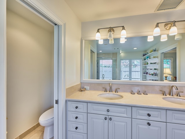 bathroom featuring vanity with extensive cabinet space, double sink, toilet, and tile floors