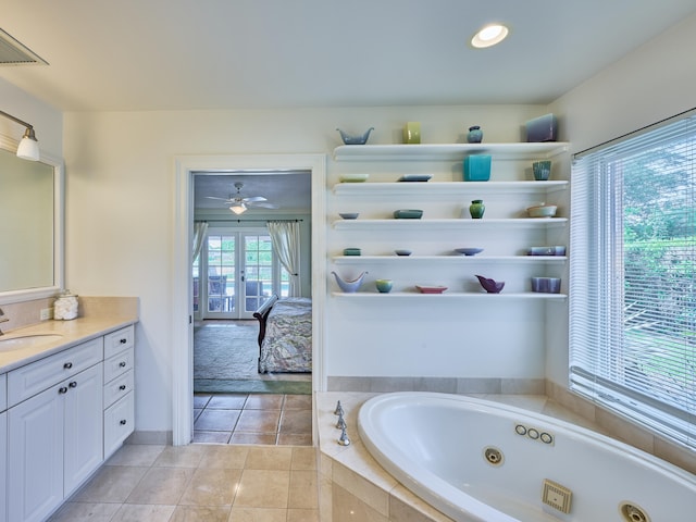 bathroom featuring ceiling fan, vanity, a relaxing tiled bath, and tile flooring