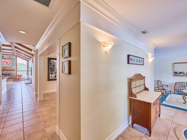 hall featuring beam ceiling, decorative columns, and light tile floors