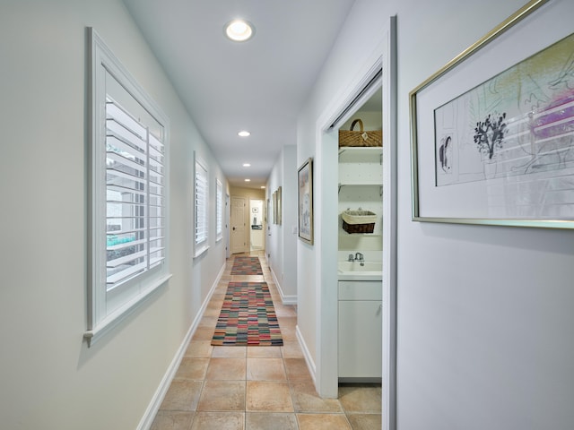 hallway featuring sink and light tile flooring