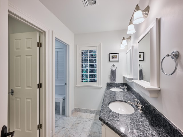 bathroom with toilet, tile floors, and dual bowl vanity