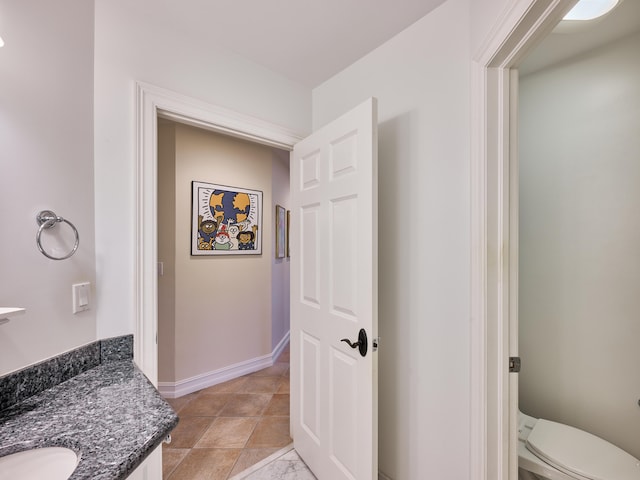 bathroom featuring toilet, tile floors, and vanity