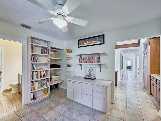 interior space featuring a textured ceiling, ceiling fan, and light tile floors