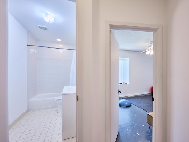 full bathroom featuring ceiling fan, a textured ceiling, shower / bath combo, toilet, and vanity