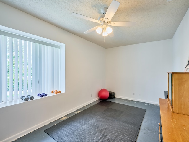 exercise room featuring plenty of natural light, ceiling fan, and a textured ceiling