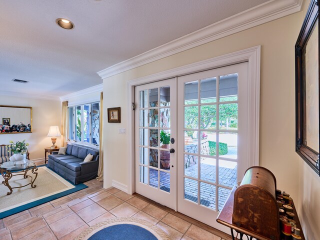 entryway with french doors, crown molding, and light tile flooring