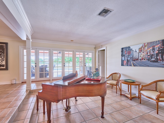 playroom featuring ornamental molding, french doors, light tile floors, and a textured ceiling