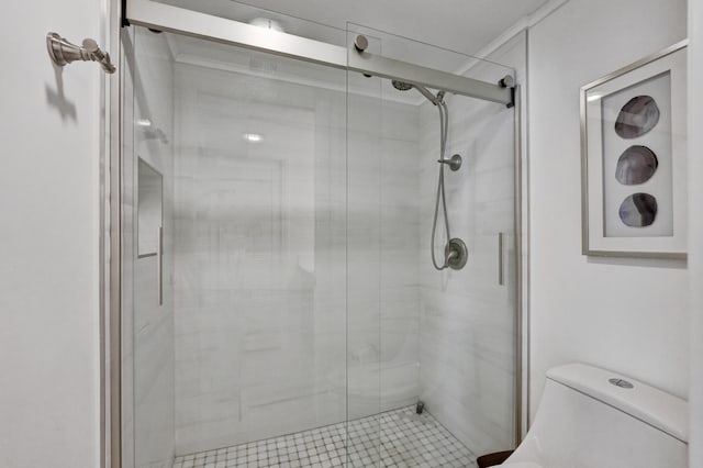 bathroom with a shower with shower door and toilet