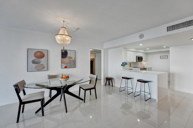 tiled dining area featuring sink and an inviting chandelier