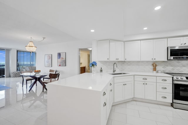 kitchen with appliances with stainless steel finishes, tasteful backsplash, sink, and white cabinetry