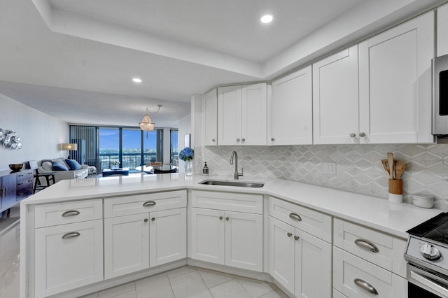 kitchen with light tile floors, tasteful backsplash, white cabinets, and sink