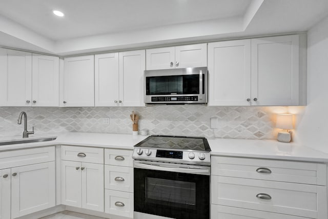 kitchen featuring appliances with stainless steel finishes, white cabinetry, and sink