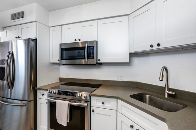 kitchen with white cabinets, appliances with stainless steel finishes, and sink