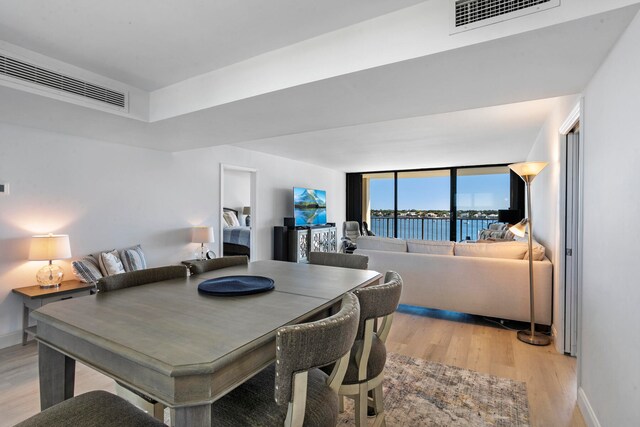 dining area featuring a water view and light wood-type flooring