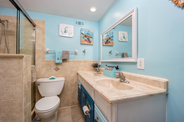 bathroom with tile walls, oversized vanity, toilet, tile floors, and dual sinks