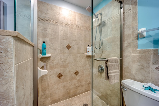 bathroom featuring walk in shower and toilet