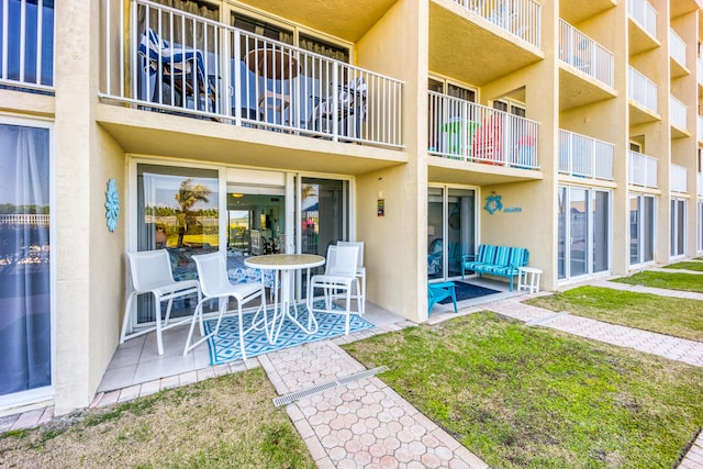 exterior space featuring a patio, a balcony, and a yard