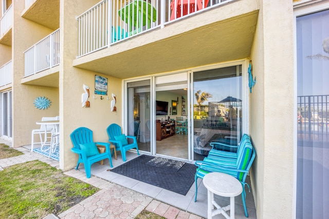 entrance to property featuring a balcony and a patio area