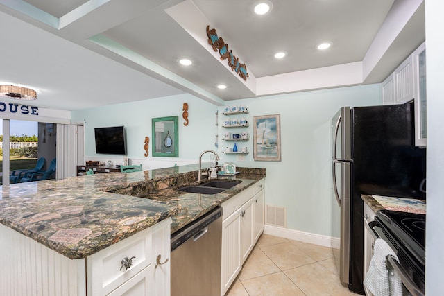 kitchen with dishwasher, dark stone countertops, white cabinetry, and range with electric stovetop