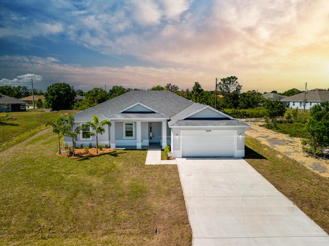 ranch-style house featuring a yard and a garage