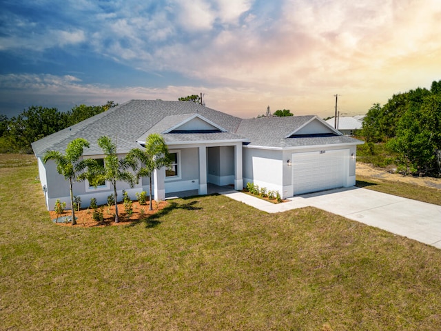 view of front facade with a yard and a garage