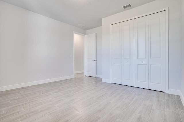 unfurnished bedroom with a closet and light hardwood / wood-style floors