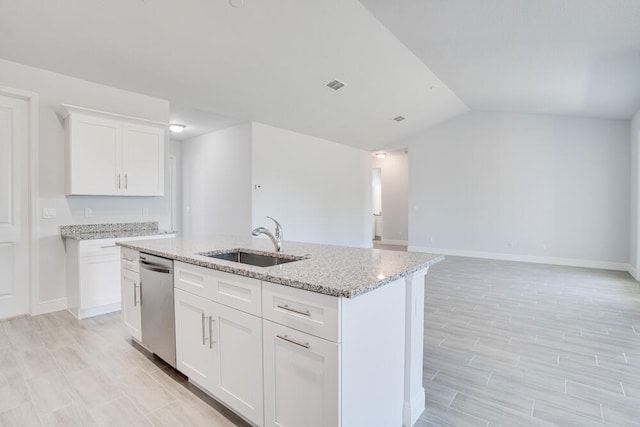 kitchen with white cabinets, stainless steel dishwasher, a kitchen island with sink, lofted ceiling, and sink