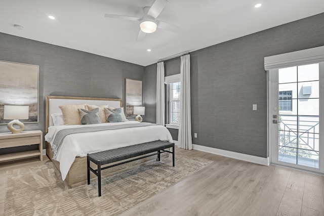 bedroom featuring multiple windows, wood finished floors, and wallpapered walls