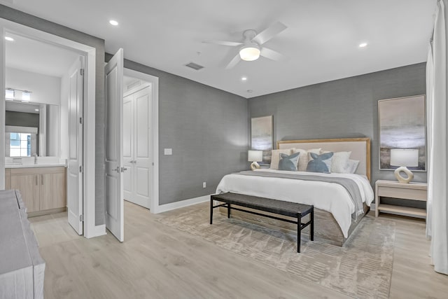 bedroom with light wood-type flooring, baseboards, ensuite bathroom, visible vents, and ceiling fan
