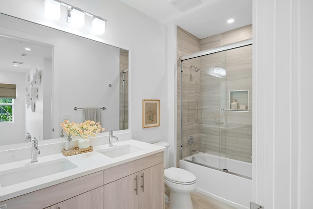 full bathroom with vanity, toilet, and bath / shower combo with glass door