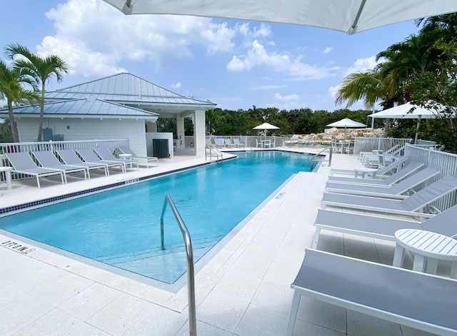 pool with a patio area and fence