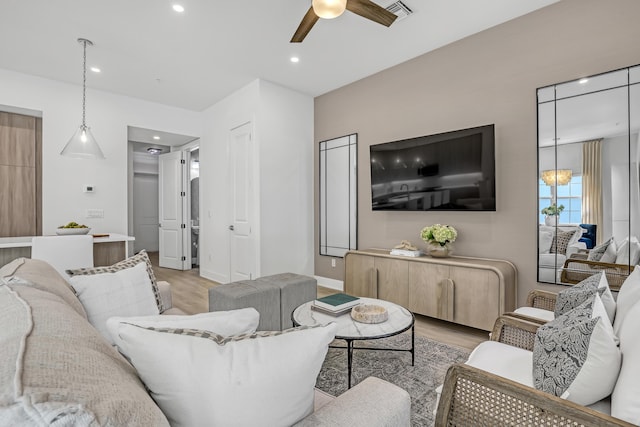 living room with light wood-style floors, ceiling fan, visible vents, and recessed lighting
