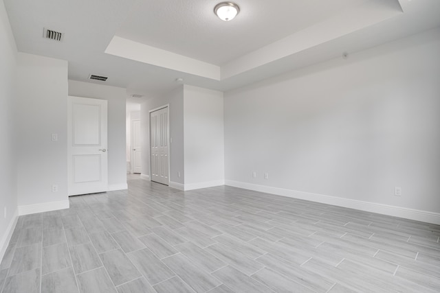 unfurnished room with a tray ceiling